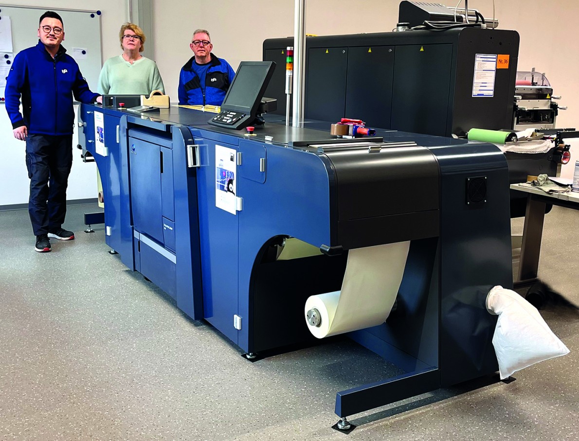 Drei Mitarbeiter von Marschall arbeiten mit der Digitaldruckmaschine.